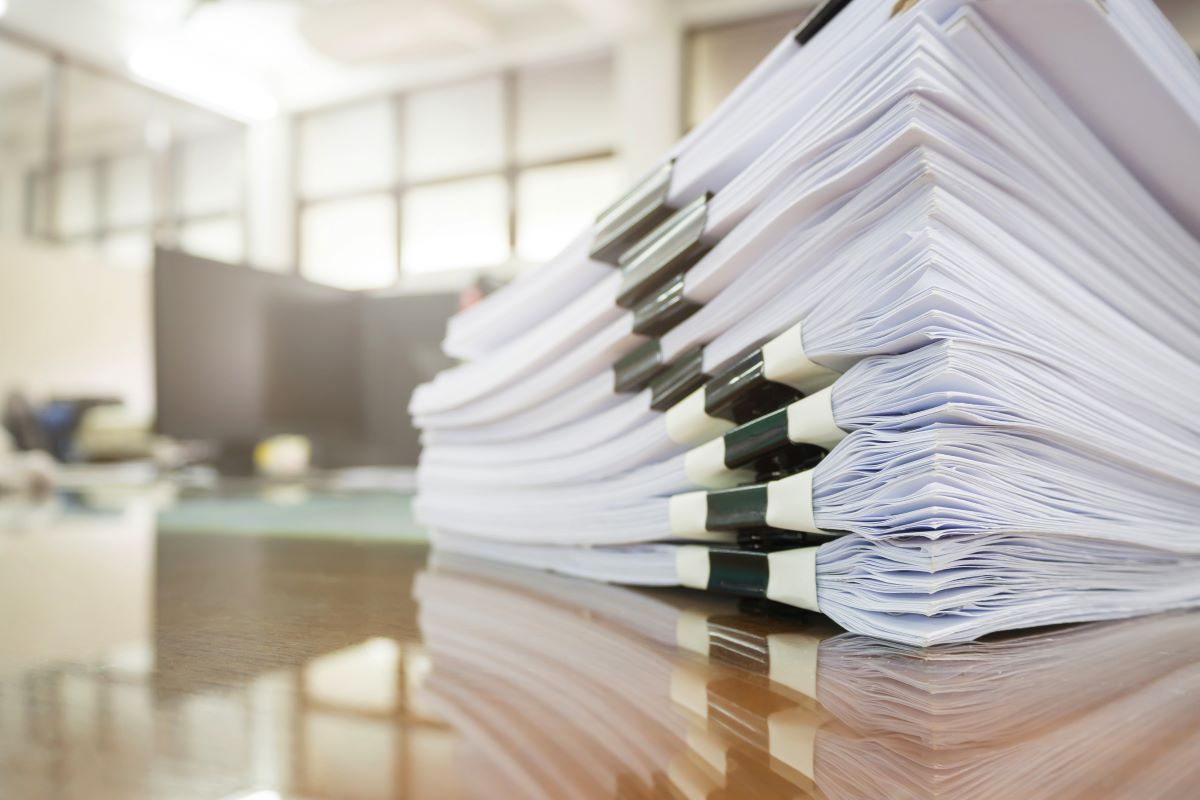 Pilha de documentos representando post sobre como revolucionar seu negócio com notas fiscais